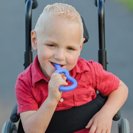 Copil folosind ARK Guitar albastru regal pentru masticație oro-motorie – extensia lungă texturată ajunge la molarii posteriori pentru input proprioceptiv maxim