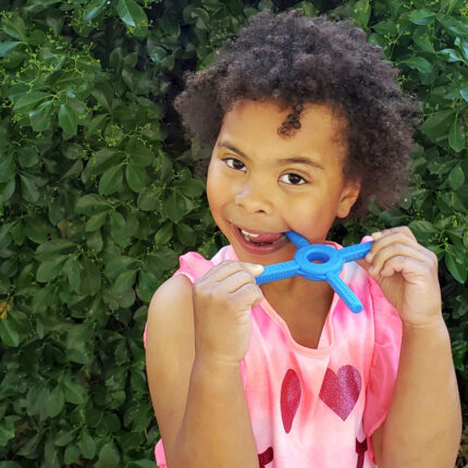 Copil folosind ARK Tetra-Bite instrument de masticatie albastru pentru logopedie