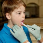 Terapeut plasează manșeta oro-Navigator lateral pe limba copilului pentru lateralizare logopedie