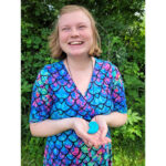 Adult purtând colierul ARK Seashell teal – colier de masticație senzorială în formă de scoică nautilus, discret și elegant